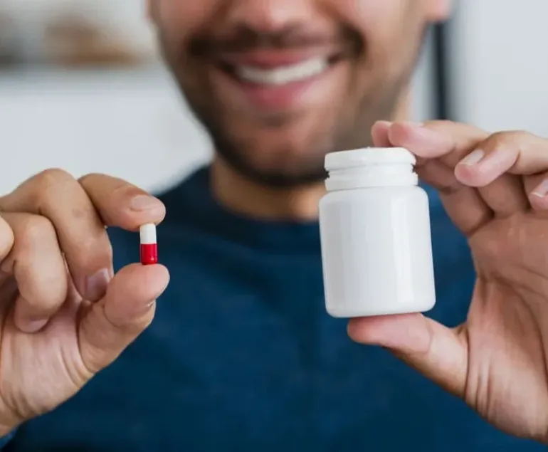close-up-young-man-holding-pill-pill-recipient-1-2