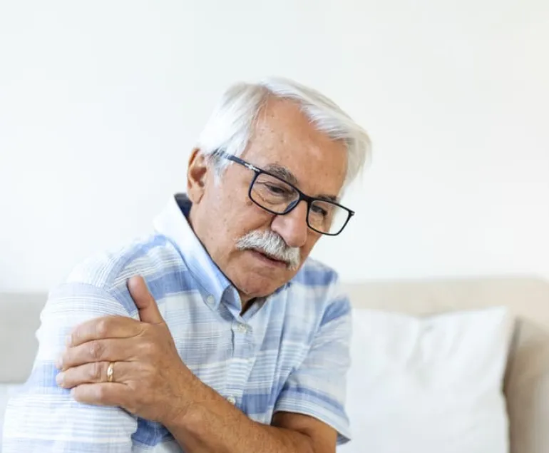 Elderly-man-holding-his-shoulder-in-discomfort,-symbolising-progressive-muscle-weakness-in-ageing-adults—supported-by-ImproSyn-and-Care-for-Muscles