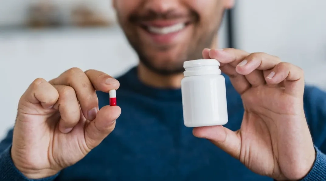 close-up-young-man-holding-pill-pill-recipient-1-2