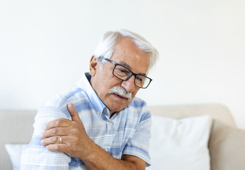 Elderly-man-holding-his-shoulder-in-discomfort,-symbolising-progressive-muscle-weakness-in-ageing-adults—supported-by-ImproSyn-and-Care-for-Muscles